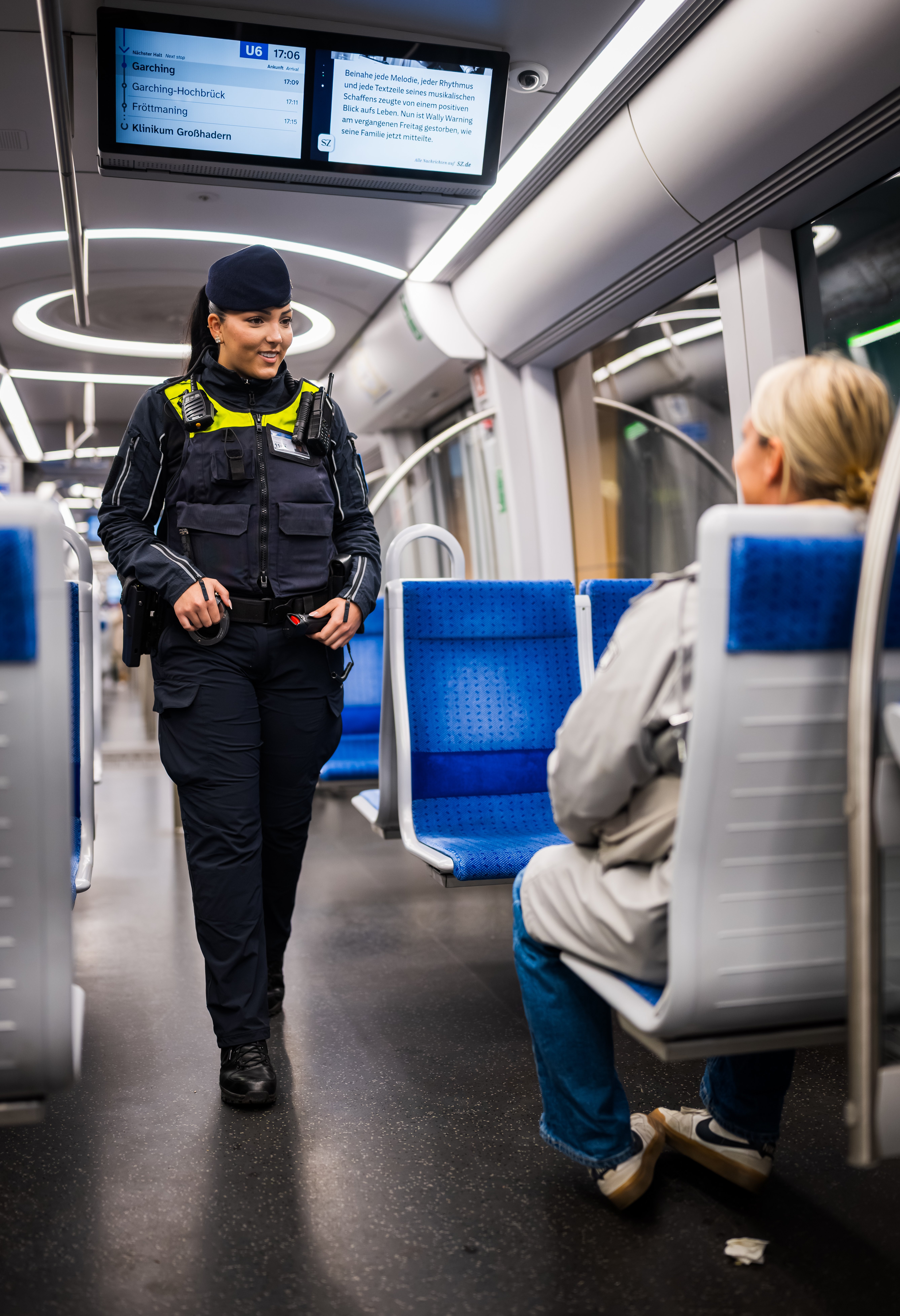 A M&uuml;nchner U-Bahnwache guard speaking to a passenger on a train.